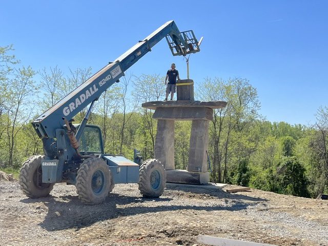 Large crane and rock structure with worker on top
